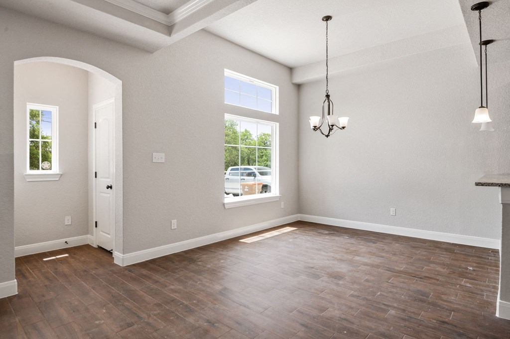 the spacious living room with hardwood flooring and a large window