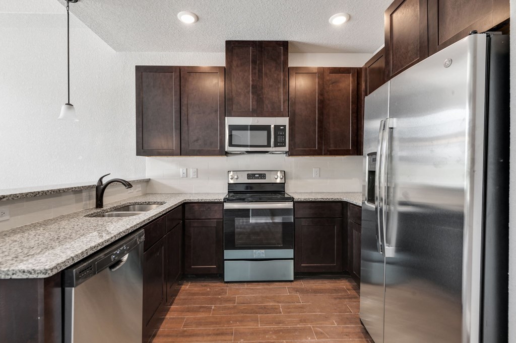 a kitchen with stainless steel appliances and a marble counter top