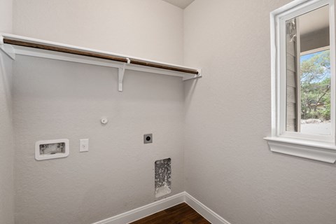 the bedroom of a house with a window and white walls
