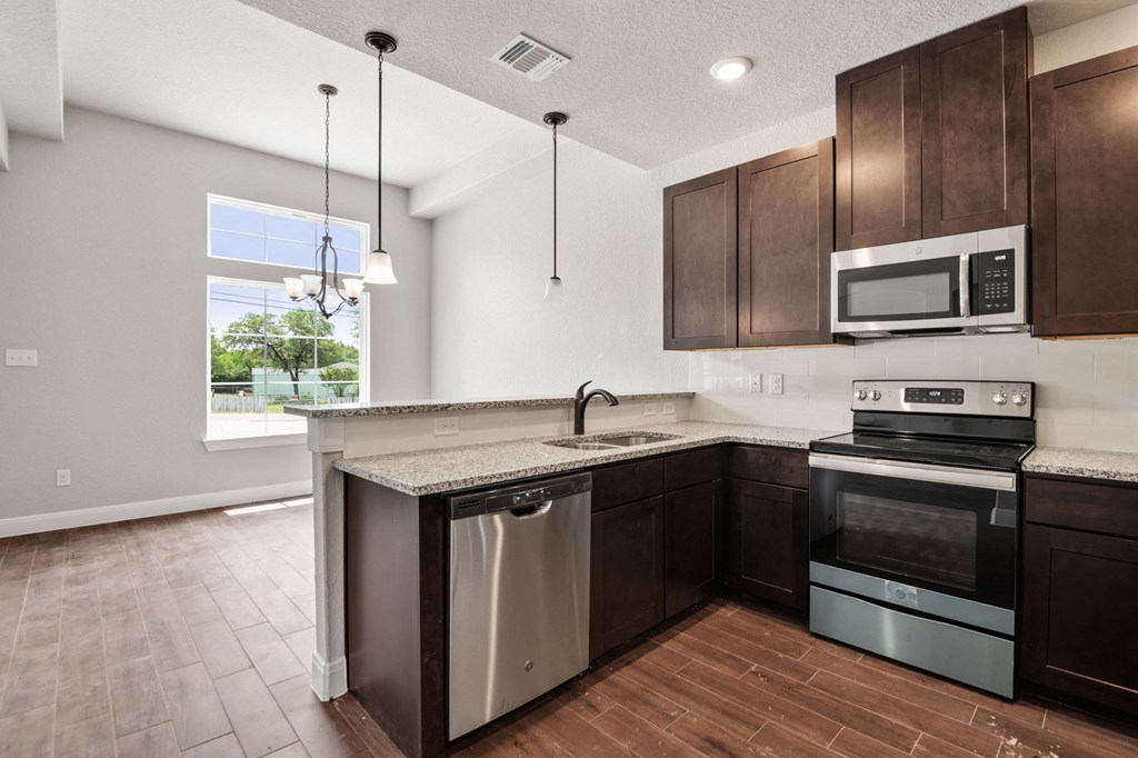 an empty kitchen with wooden cabinets and stainless steel appliances