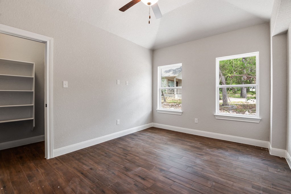 an empty living room with hard wood floors and a ceiling fan