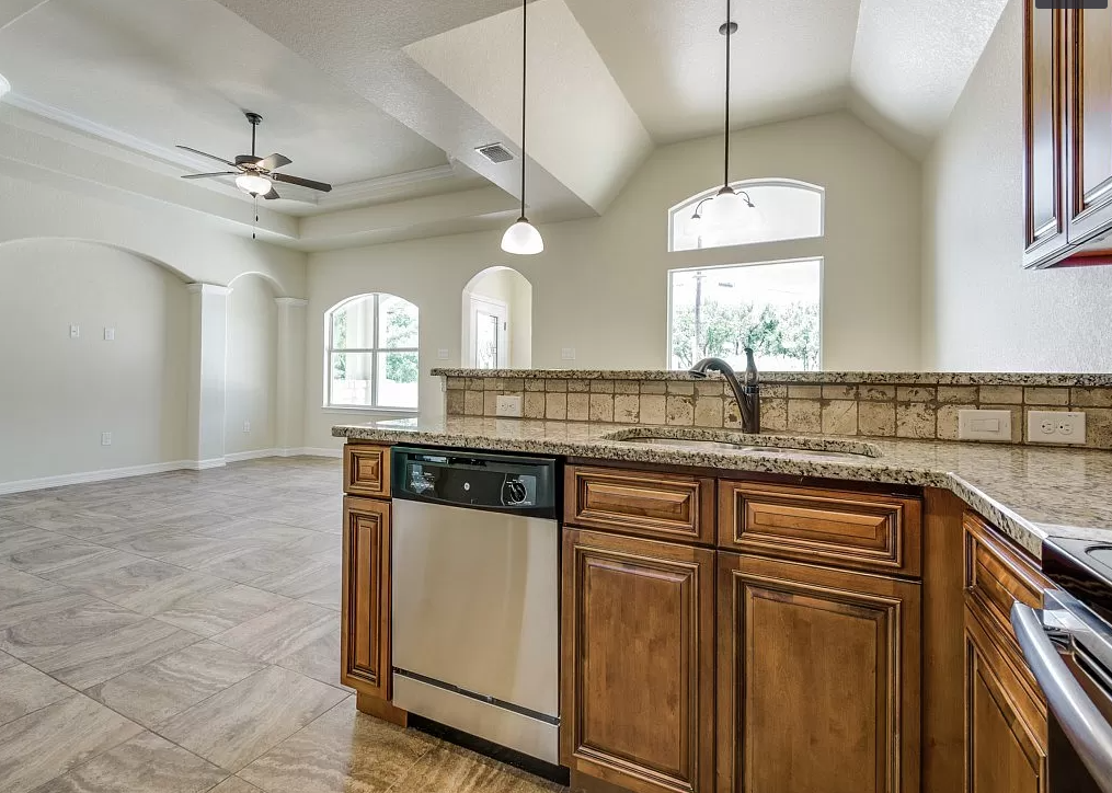 an empty kitchen with a sink and a dishwasher