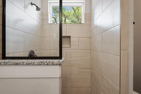 the bathroom has a large mirror and a shower with a window