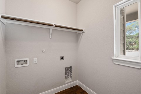 the bedroom of a house with a window and white walls