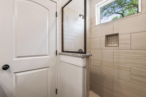 a small bathroom with a shower and a white door