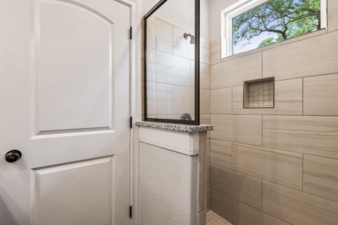 a small bathroom with a shower and a white door