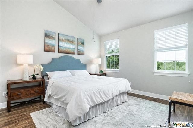 a white bedroom with a bed and two windows