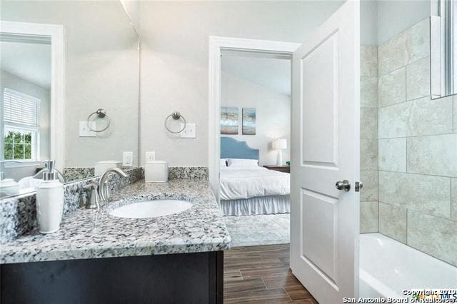 a bathroom with a sink and a tub and a mirror