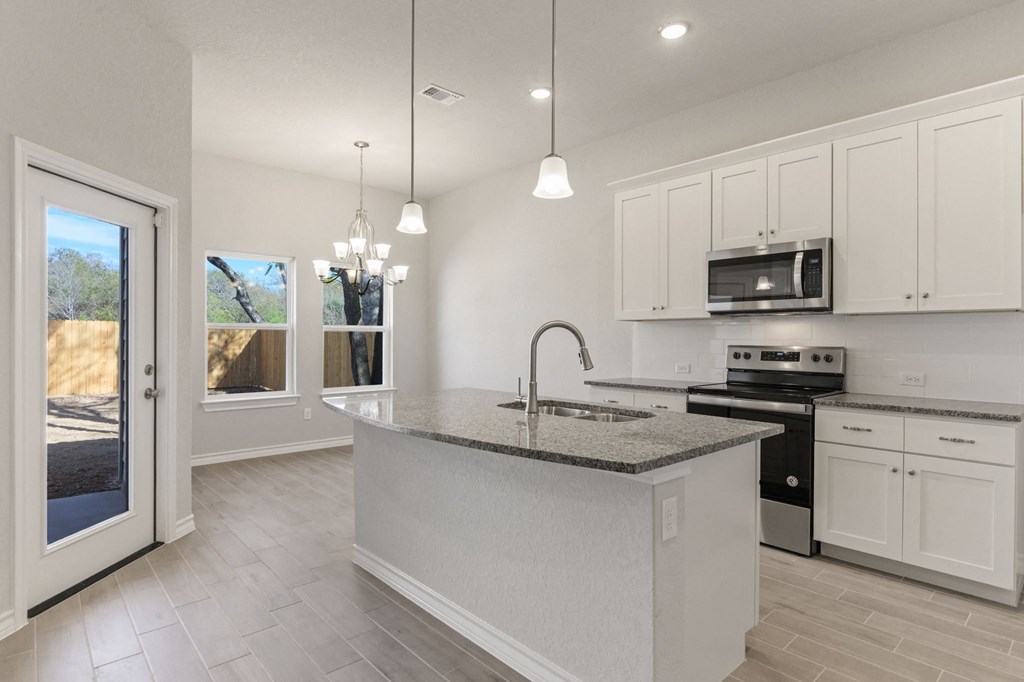 a kitchen with an island and a door to a patio