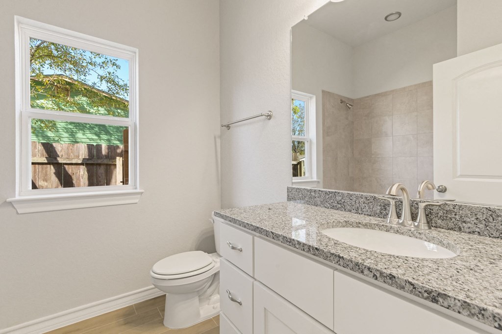 a bathroom with a sink and a toilet and a window