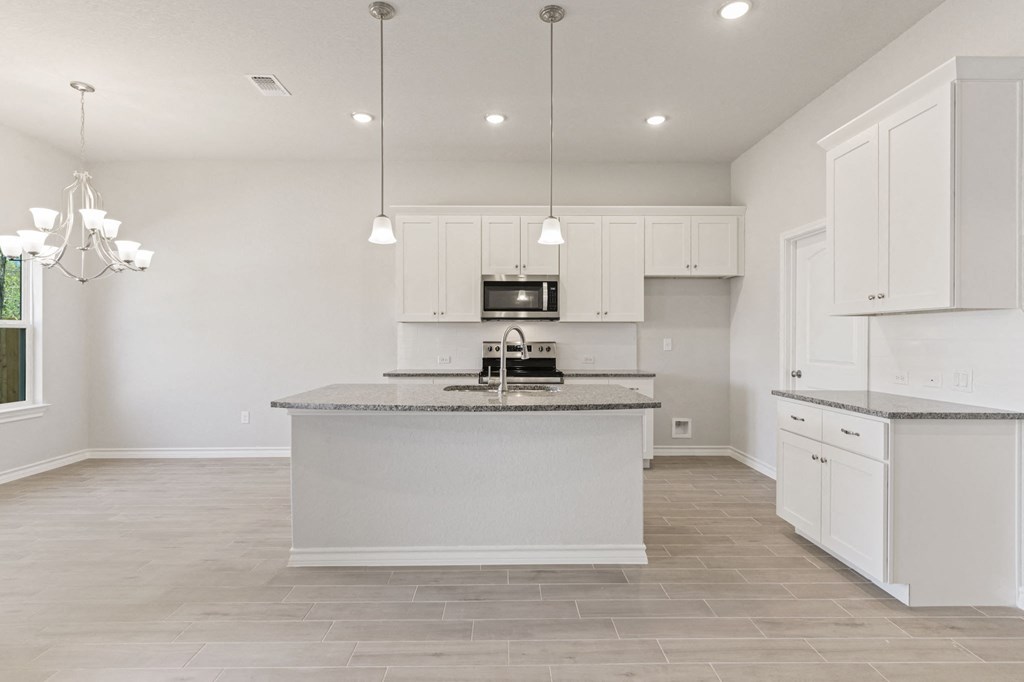 a large kitchen with white cabinets and a counter top