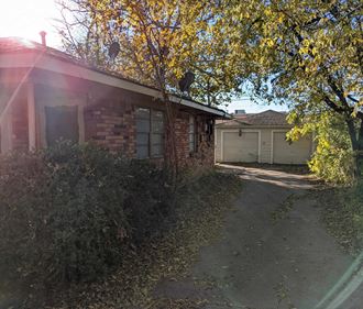 a brick house with a garage and a tree in front of it