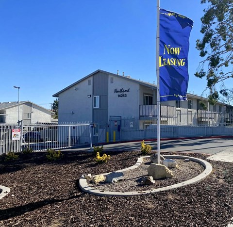 A blue "Now Leasing" banner is displayed in front of a building with the address "Airport 9243".