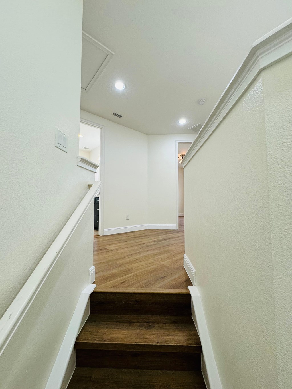 a view of a staircase in a home with white walls and wood floors