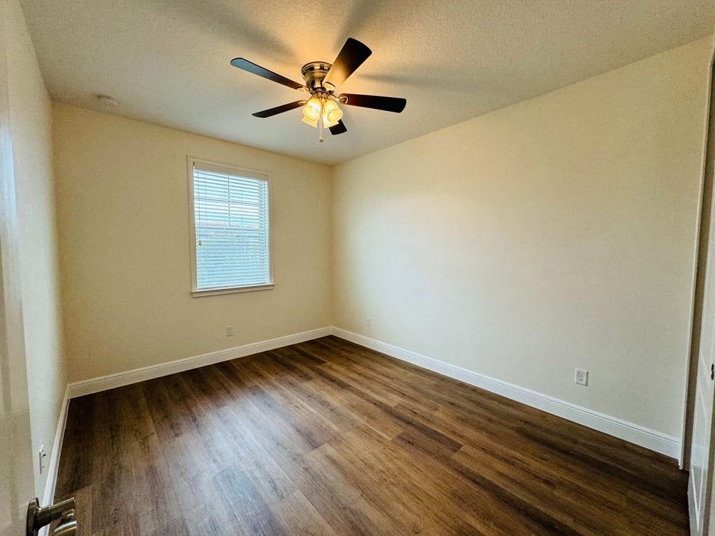 a living room with hardwood floors and a ceiling fan