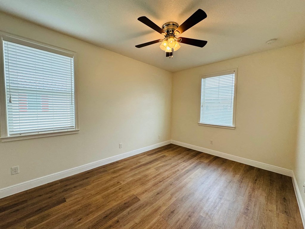 a living room with hardwood floors and a ceiling fan