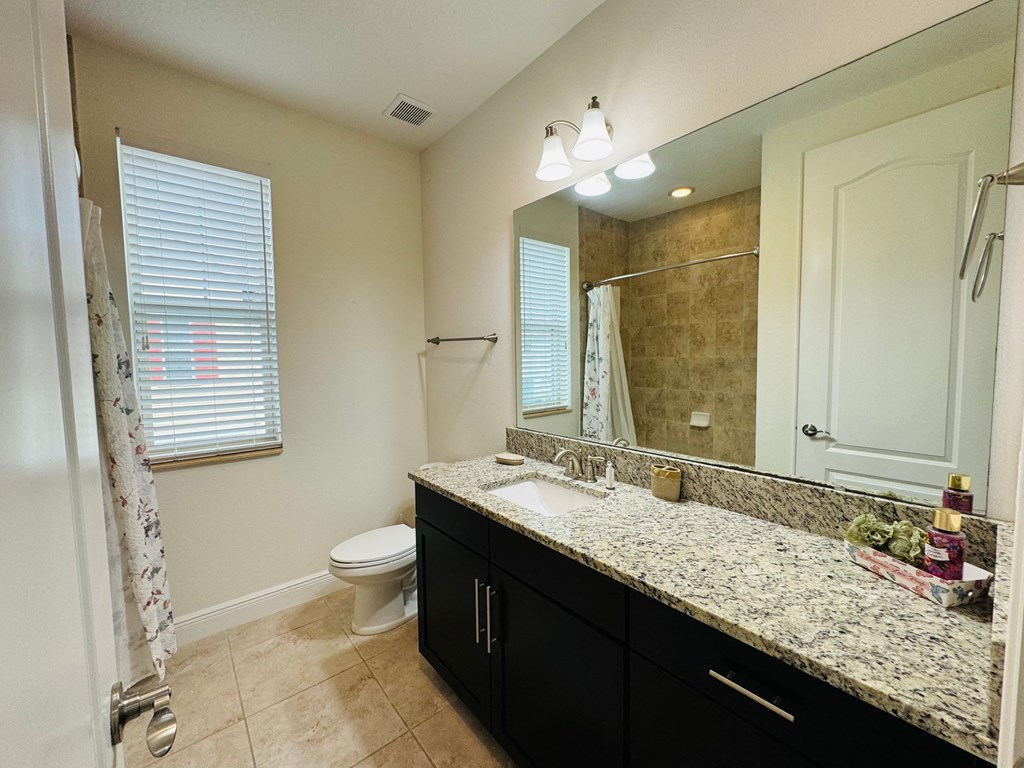 a bathroom with a large mirror and a sink and a toilet