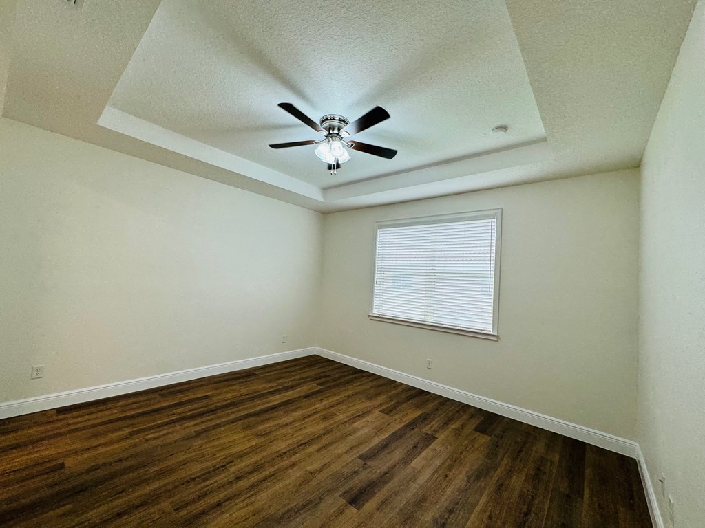 a living room with hardwood floors and a ceiling fan