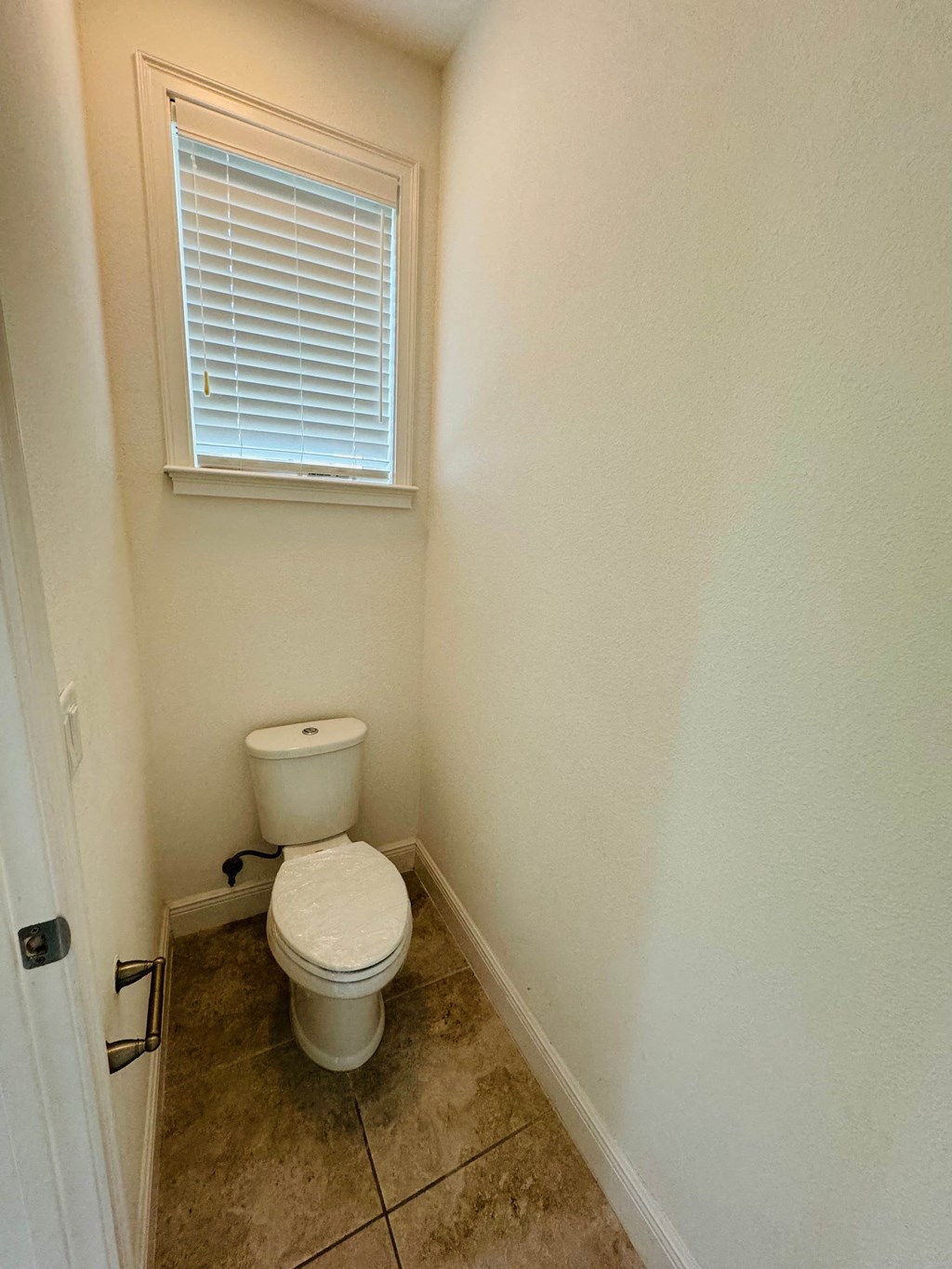a small bathroom with a toilet and a window