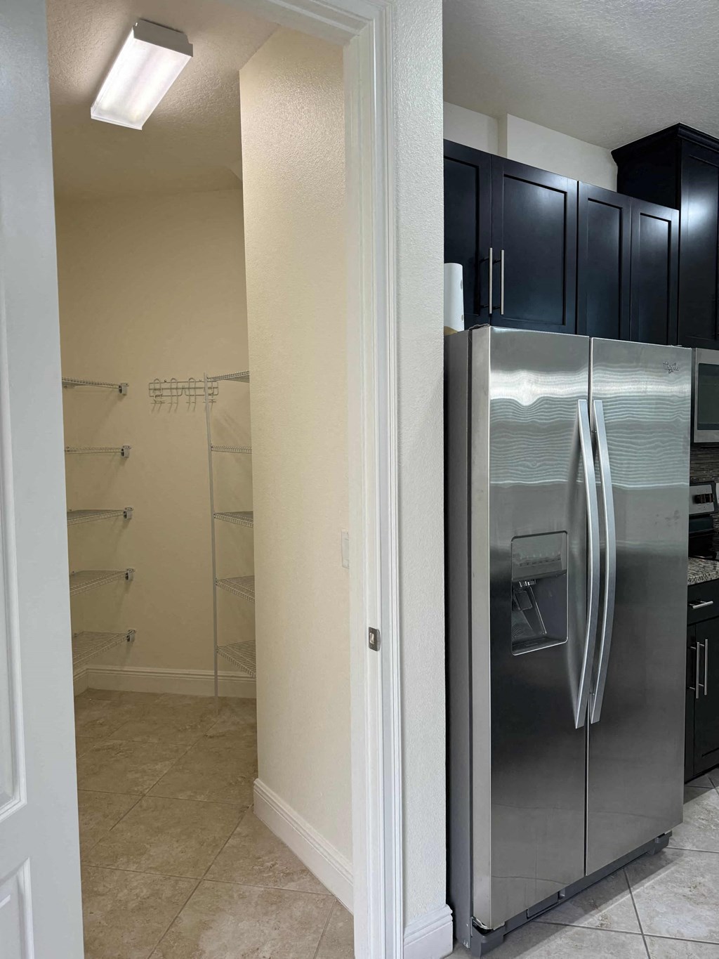 a kitchen with a stainless steel refrigerator and black cabinets