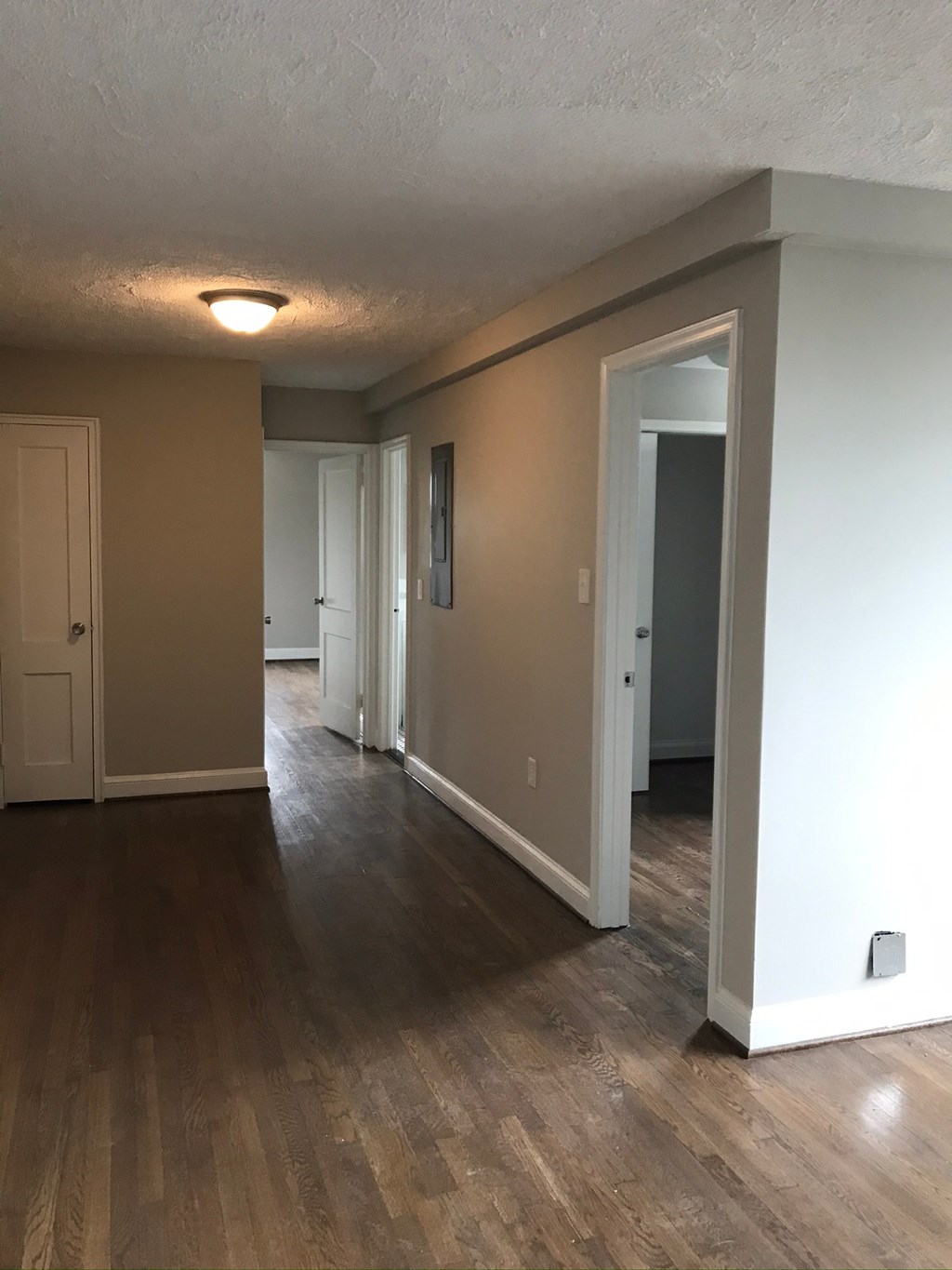 a living room and hallway with wood floors and white walls