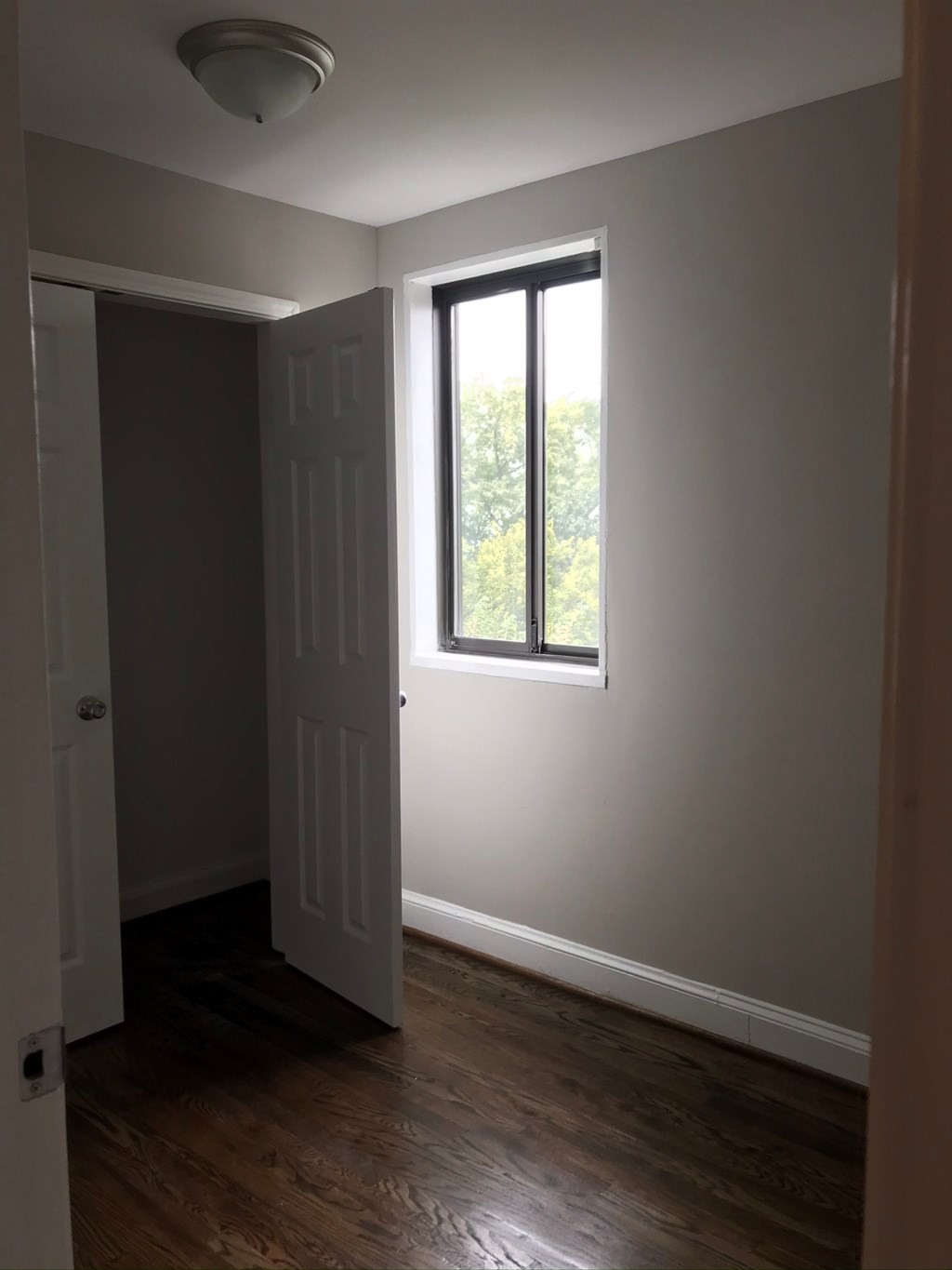 an empty room with a window and a door