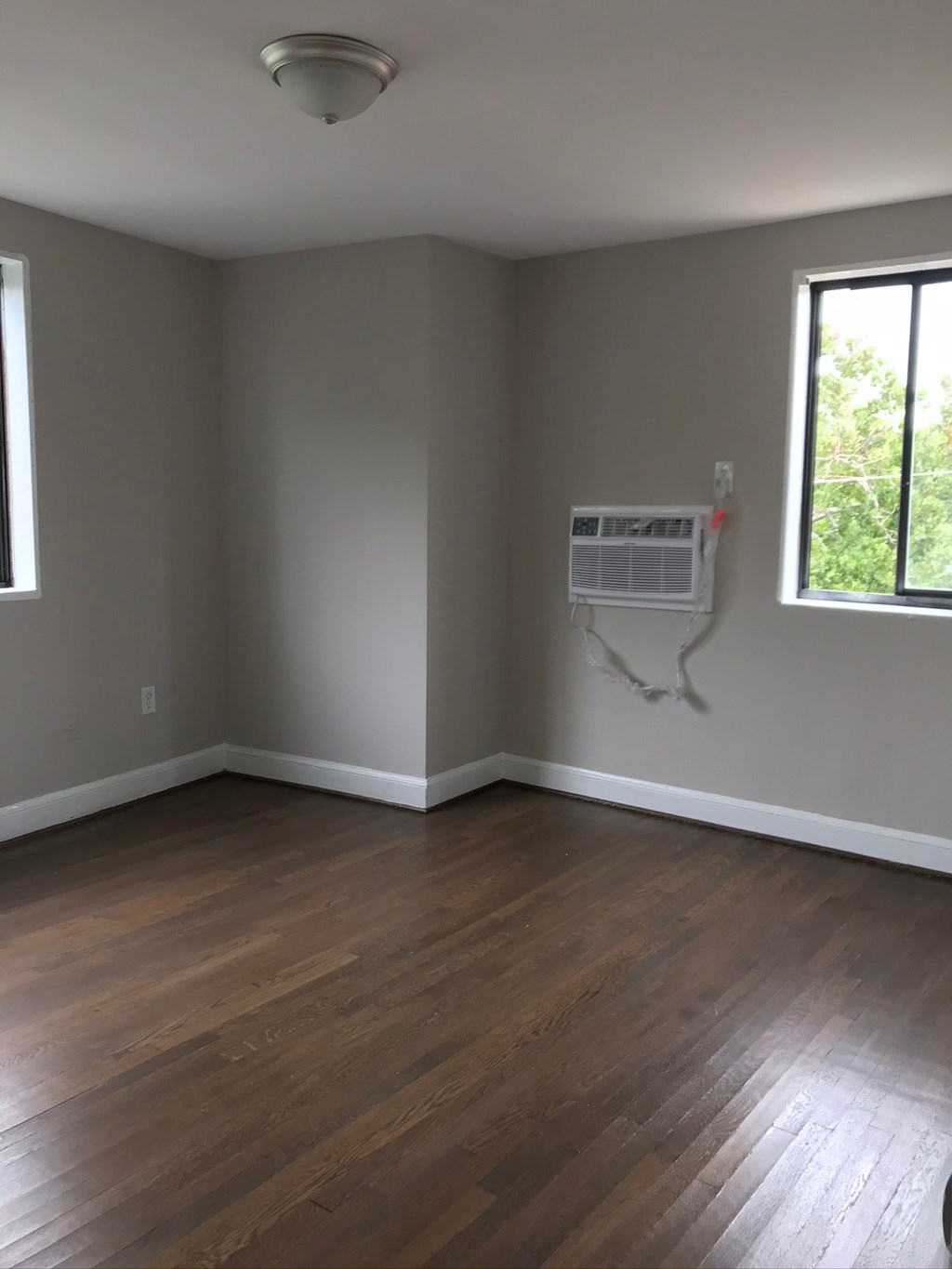 an empty room with wooden floors and an air conditioner on the wall