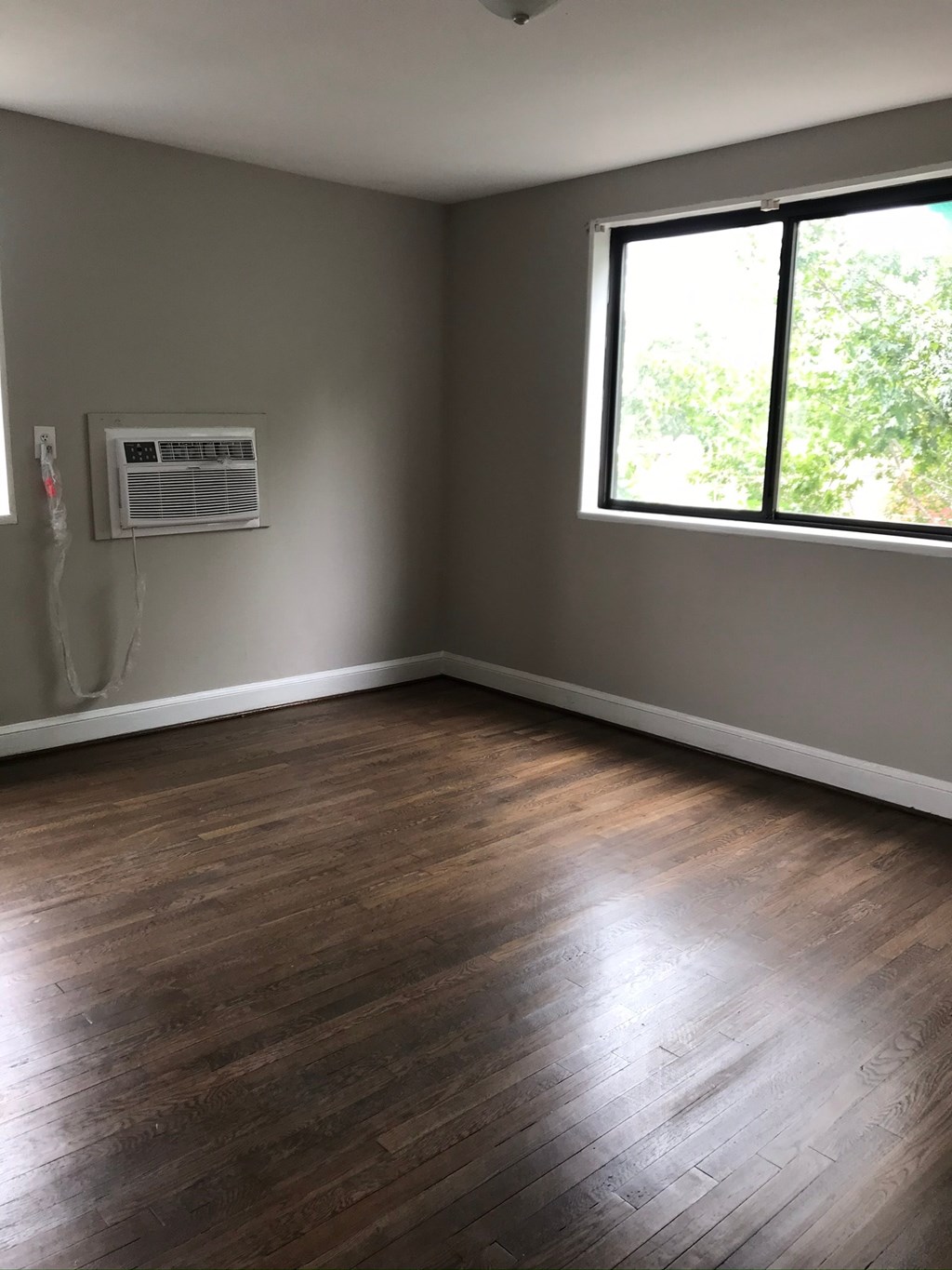 an empty room with wooden floors and a window