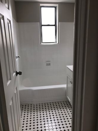 a small bathroom with a tub and a window