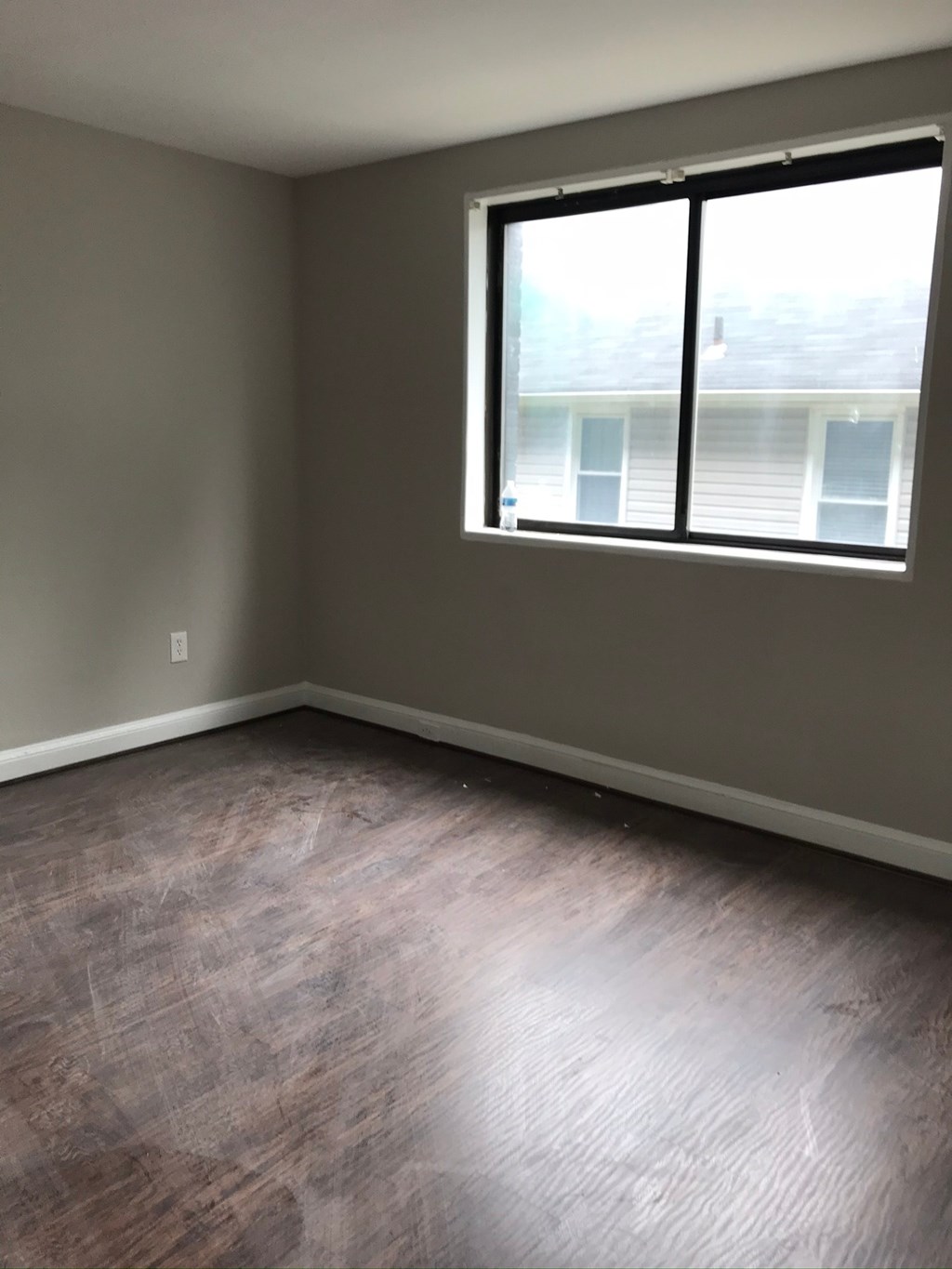 an empty room with wood floors and a window