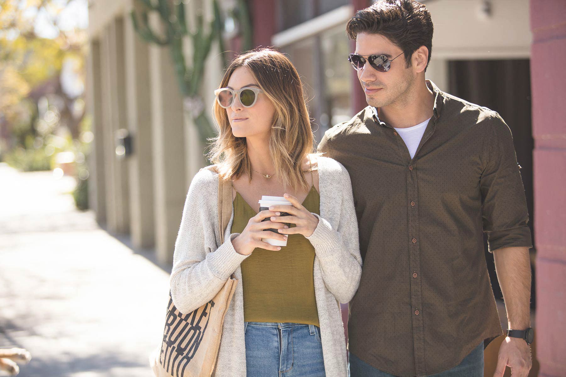 a man and a woman walking down a street with a cell phone