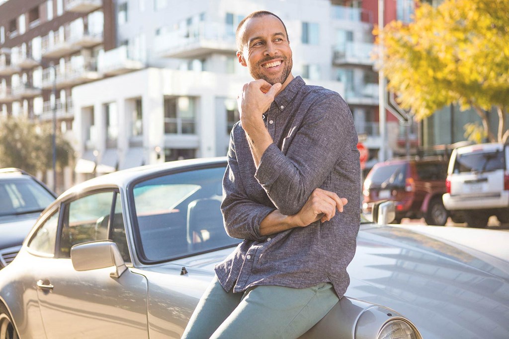 a man sitting on the hood of a car