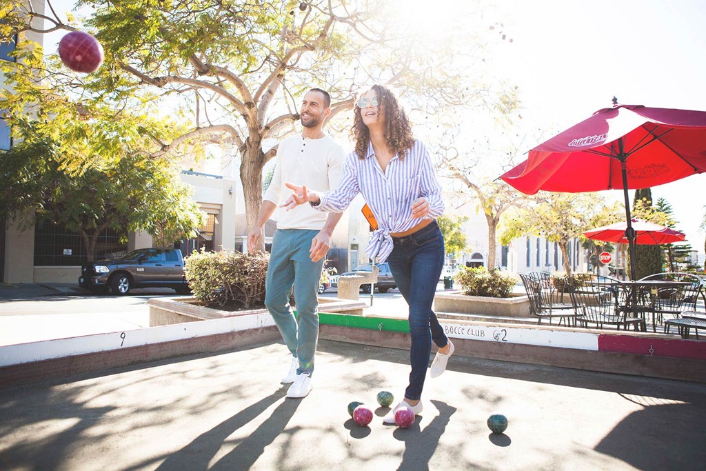 a man and a woman walking with balls on the ground