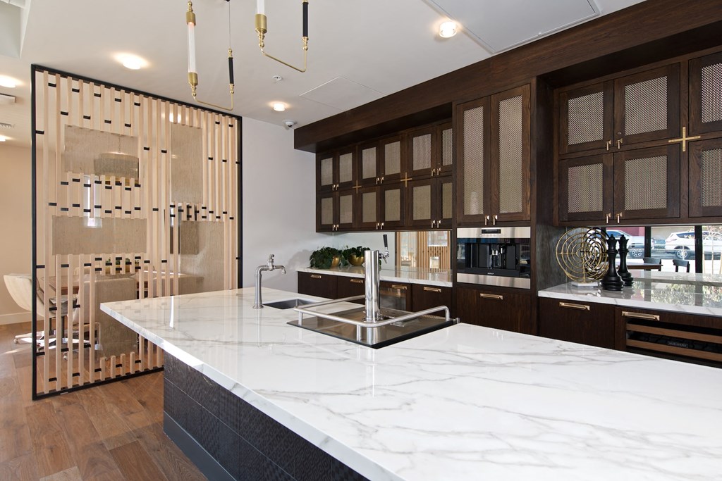 a large kitchen with marble counter tops and wooden cabinets