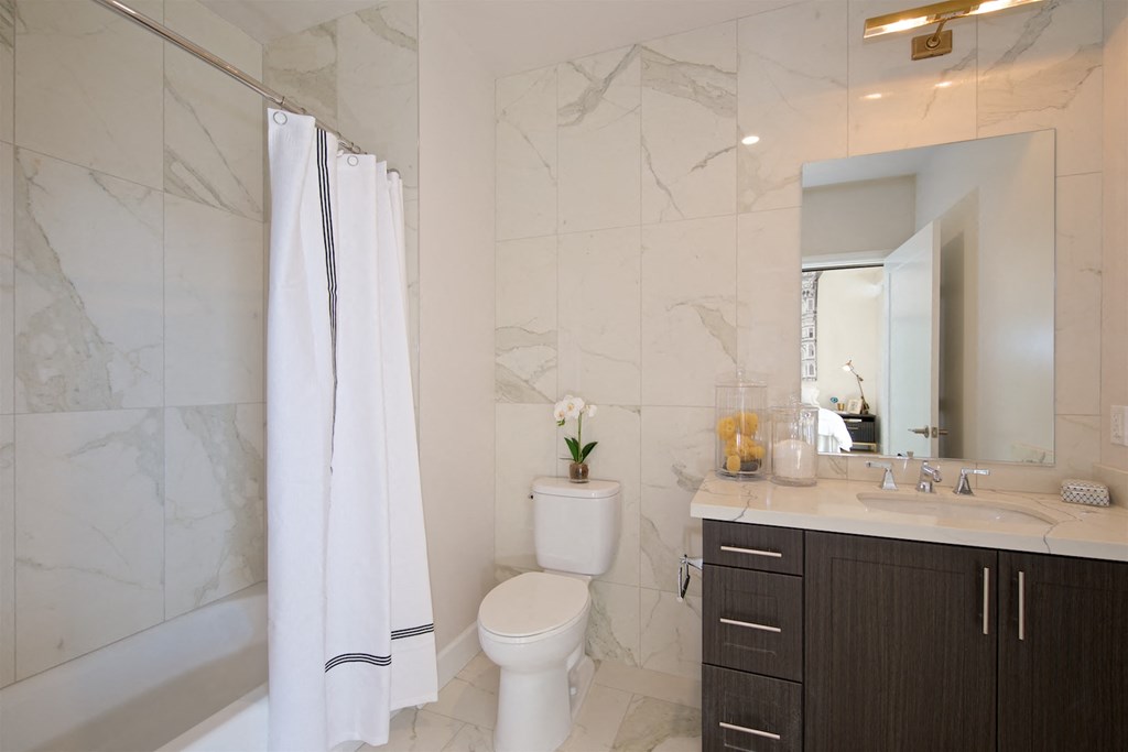 a bathroom with a shower toilet sink and a mirror