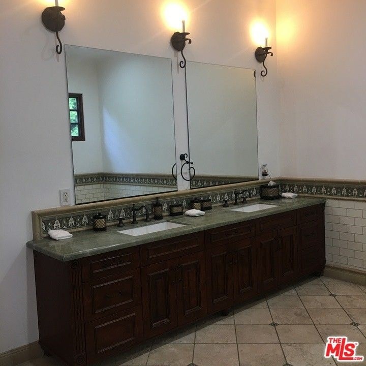 a bathroom with two sinks and a large mirror