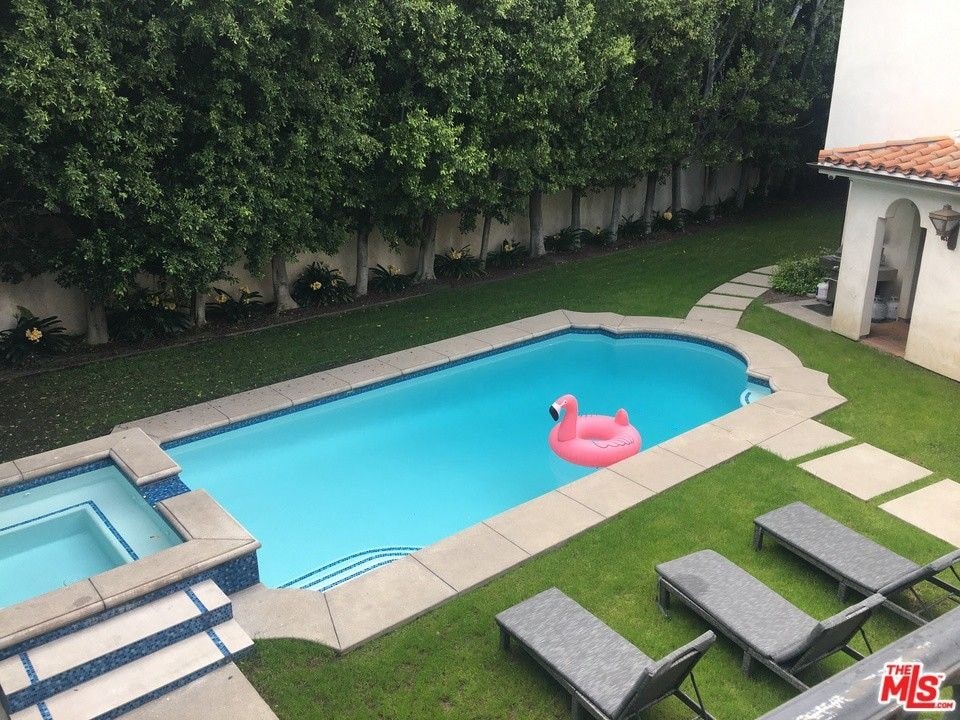 a swimming pool in the backyard of a house with a pink rubber duck in it