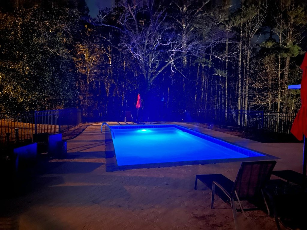the swimming pool at night with a blue light in it