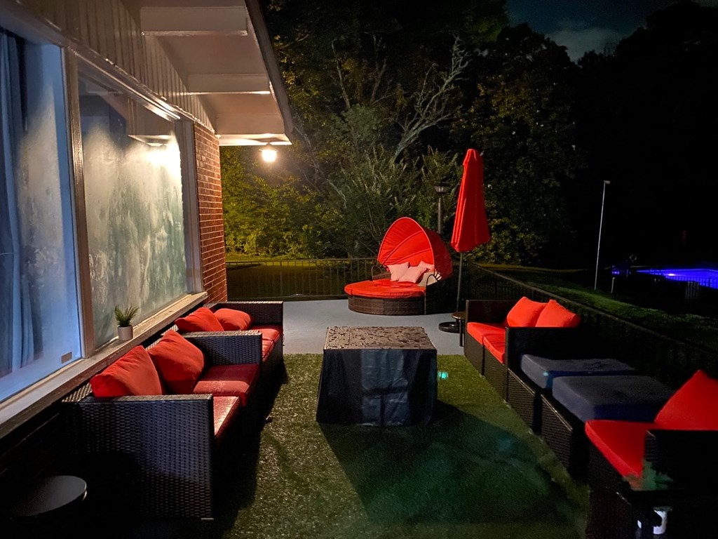 a patio at night with couches and a table