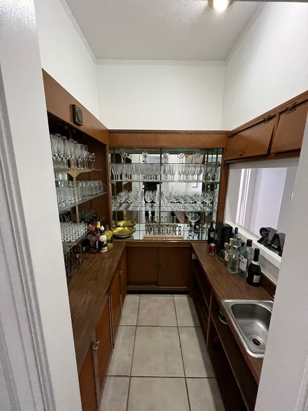 a small kitchen with wooden cabinets and a sink and a window