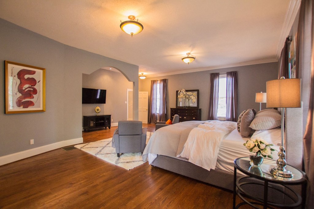 a bedroom with a large bed and a living room with a tv