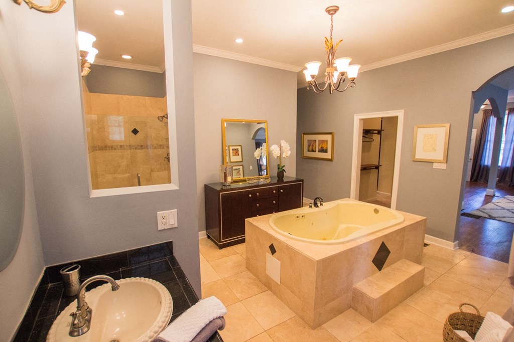 a bathroom with a large tub and a sink and a mirror