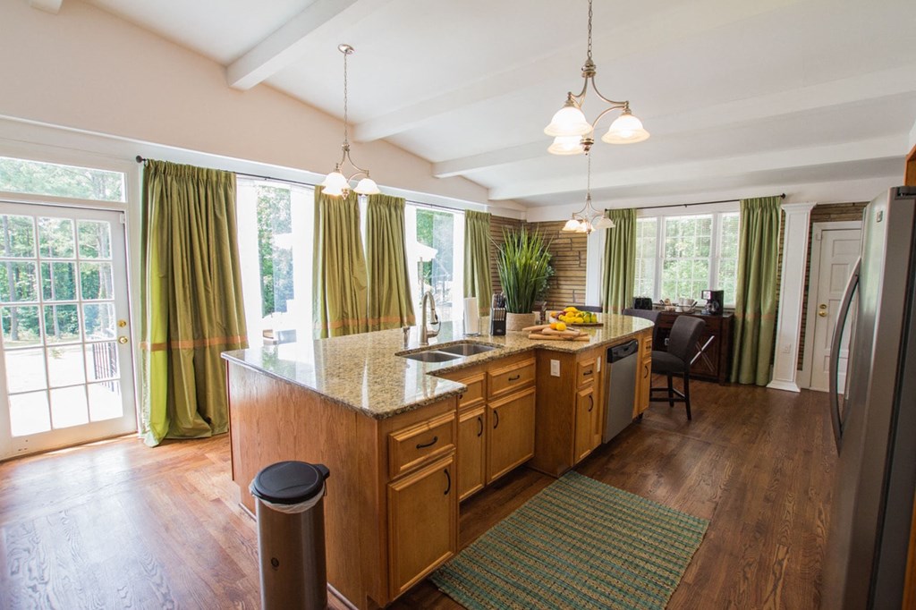 a kitchen and dining room with green curtains and a large window