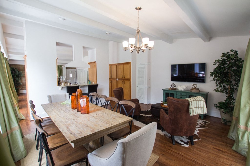 a dining room and living room with a wooden table and chairs
