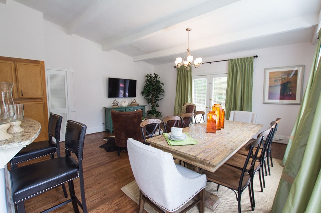 a dining room and living room with a table and chairs and a tv