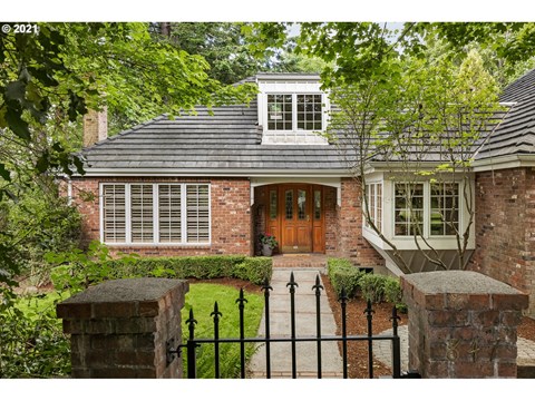 the front of a brick house with a wooden front door
