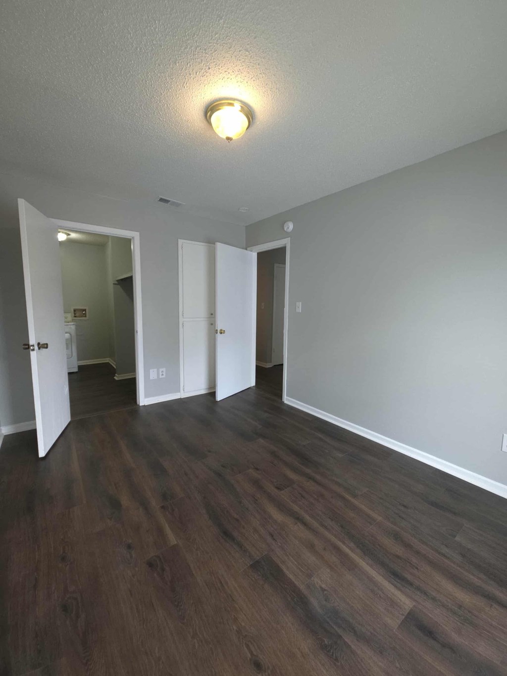 A room with a light on and wood flooring.
