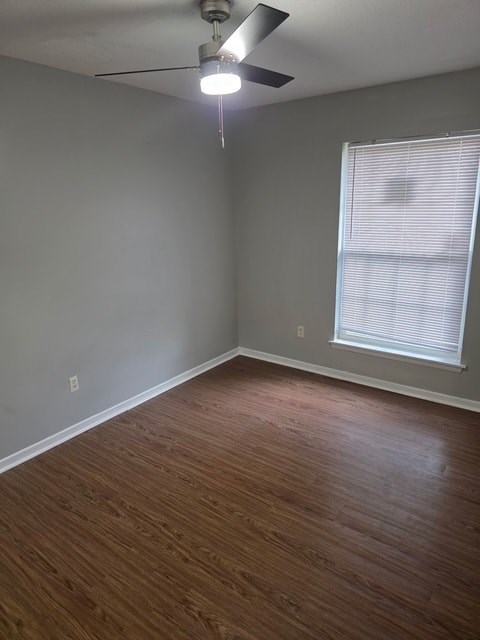 A room with a ceiling fan and a window with blinds.