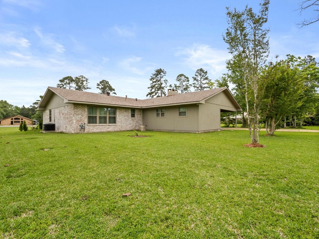 the front of a house with a yard and a tree