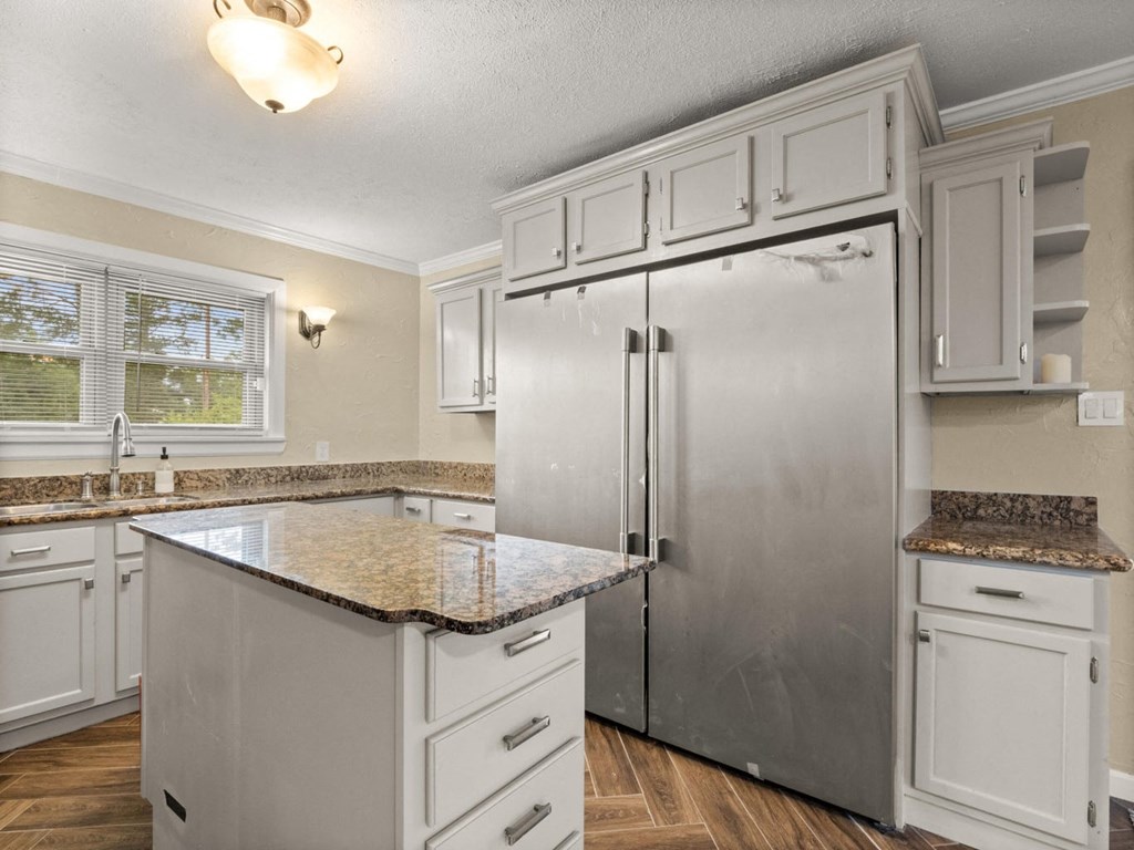 a kitchen with white cabinets and a stainless steel refrigerator